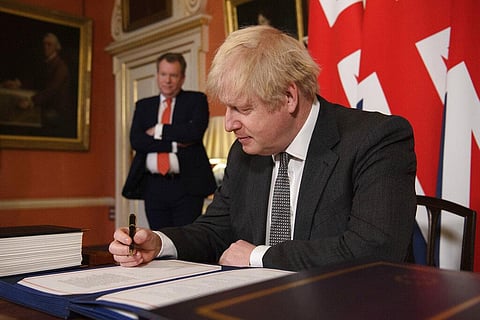 Boris Johnson signs the EU-UK Trade and Cooperation Agreement at 10 Downing Street, London Wednesday Dec. 30, 2020. (Photo | AP)