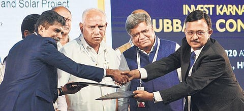 Rajesh Mehta (left) exchanging the MoU on setting up a e-car manufacturing unit in Dharwad during the Invest Karnataka conference in Hubballi on Friday | D Hemanth