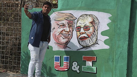 In this file Image from 2020, a man takes a selfie with portraits of US President Donald Trump and Indian Prime Minister Narendra Modi painted on a wall ahead of Trump's visit, in Gujarat's Ahmadabad. 