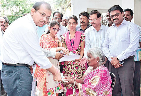Principal Secretary of Panchayat Raj and Rural Development Gopal Krishna Dwivedi handing over pension to a woman at Ibrahimpatnam on Saturday | Express