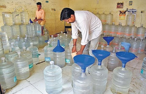 Residents filling their water cans at wholesale shops on  Friday| R Satish Babu