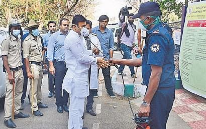 An RGICD hospital staffer sanitises Medical Education Minister Dr K Sudhakar in Bengaluru on Friday  | Shriram B N