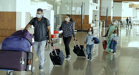 A family at Kochi airport wearing safety masks. (Photo | Arun Angela, EPS)
