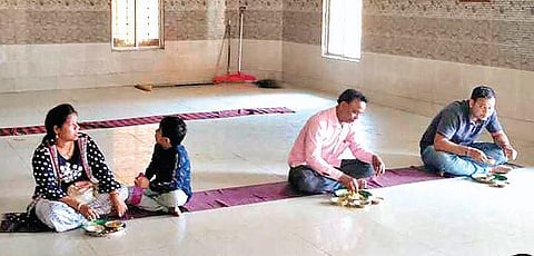 People maintaining a distance of one metre while having ‘prasad’ in Bhoga Mandap at Samaleswari temple on Monday. (Photo | EPS)