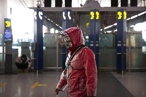 A  traveler wears a respirator, goggles, and a raincoat as he walks through Beijing Capital International Airport in Beijing, Saturday, March 28, 2020. (Photo | AP)