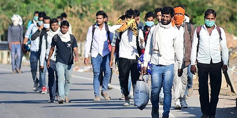 Migrant laborers who were working in Bengaluru are returning to their natives by foot spotted near the Nelmangala Toll Gate. (Photo | Shriram, EPS)