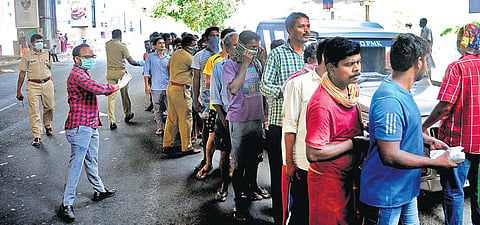 Migrant labourers queue up at Kaloor junction to get food parcels provided by Kerala Police and Nanma Foundation | A SANESH