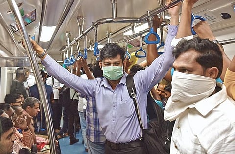 Cautious commuters wearing protective masks ride on a Metro train in Bengaluru  on Wednesday | Vinod kumar T