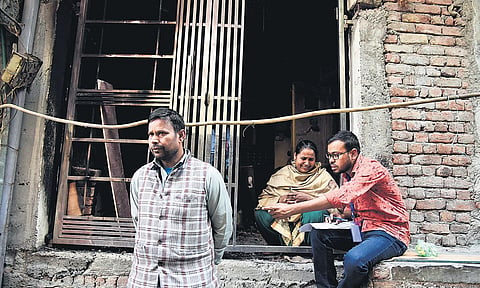 A victim of the riots breaks down as a volunteer undertakes a survey for compensation disbursal, in northeast Delhi | express