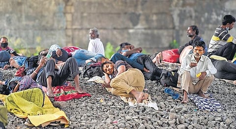 Stranded migrant workers sleep under a flyover next to the railway tracks. | pti
