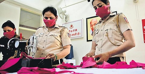 Delhi Police personnel stitch face masks for the poor on Saturday. (Photo | EPS/Shekar Yadav)