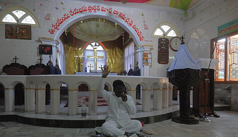 A father prays at an empty church on the occassion of Easter at Tdepalli in Guntur district on Sunday. (Photo | Prasant Madugula, EPS)