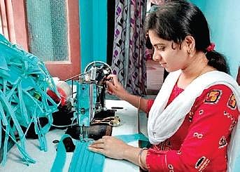 A woman stitching masks in Sircilla