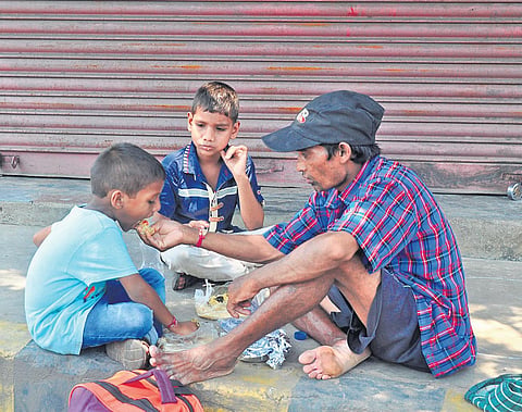 Venkata Rao, who is on his way to Golladi, feeds his sons in Bobbili. (Photo | EPS/G SATYANARAYANA)