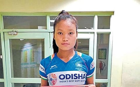 Striker Lalremsiami uses stretch cords to do bodyweight exercises like squats