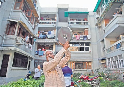 People come out to clap, clang utensils at an apartment to cheer health workers after PM Modi's call. (Photo | Anil Shakya/EPS)