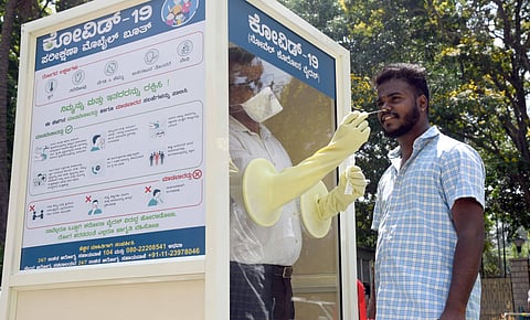 A health worker collects a man’s nasal swab at a mobile testing kiosk opened at the CM’s residence, in Bengaluru  on Thursday | Nagaraja Gadekal