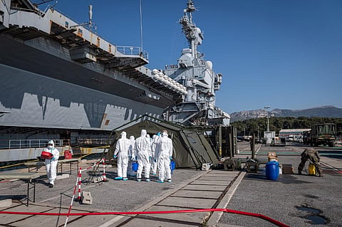 Team led by navy soldiers, firefighters and members of a Navy's disinfection special unit, disinfecting materials near the French aircraft carrier Charles de Gaulle. (Photo| AFP)