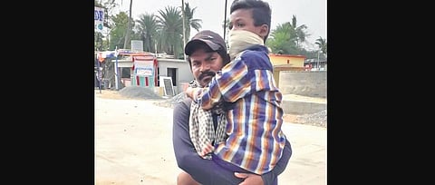 Chakradhar holds his physically challenged son in arms 