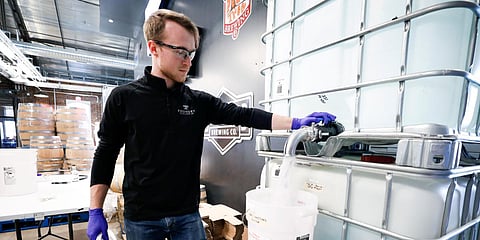 A distiller fills a container with hand sanitizer at the Foundry Distilling Co. on Friday in West Des Moines, Iowa. (Photo| AP)