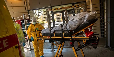 A coronavirus patient is transferred from a hospital to a home for elderly by members of the medical staff of Klinicare in Belgium. (Photo | AP)