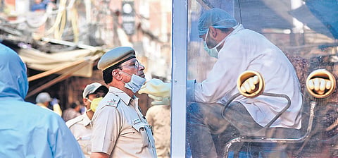 A health worker collects swab samples from a police personnel at a mobile COVID-19 testing centre in New Delhi. (Photo| Parveen Negi, EPS)