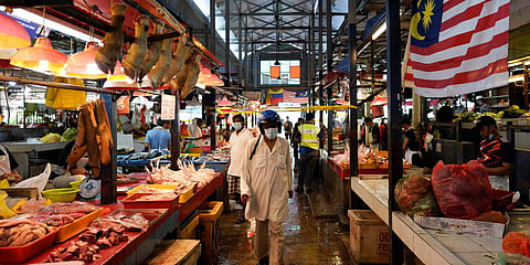 A man wearing a face mask to help curb the spread of the coronavirus shops at a wet market in downtown Kuala Lumpur. (Photo| AP)
