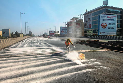 Workers spread a powder for the repairment of the Andheri flyover road during ongoing COVID-19 lockdown in Mumbai. (Photo | PTI)