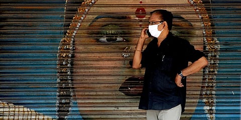 A mask-clad individual is speaking over phone in front of a jewellery shop in Kaloor on Friday.  (Photo| EPS, A Sanesh)