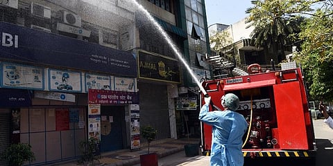 Fire service personnel spray disinfecting liquid in the residential area at Nizamuddin adjoining Nizamuddin Dargah during lockdown. Express Photo by Parveen Negi