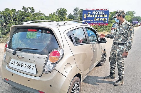Police inspect documents and explain rules of inter-state travel to inbound passengers at the Kerala-Tamil Nadu border on Tuesday | Express