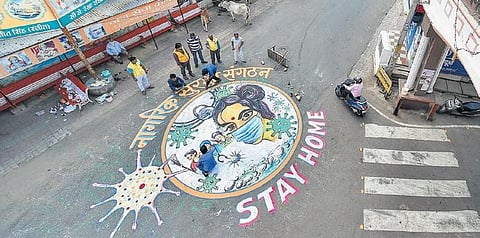 Nagrik Suraksha Sangathan volunteers paint a graffiti on a road to create awareness on coronavirus in Lucknow | Pti