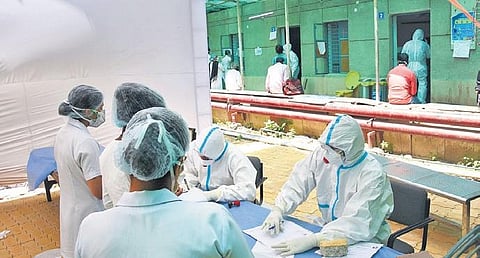 Doctors wearing protective suits sit at COVID ward of RML Hospital.