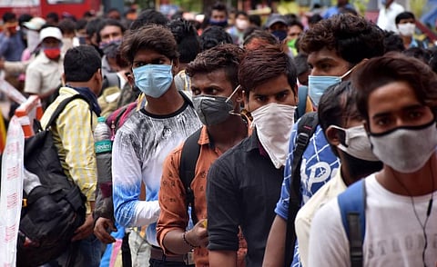 Migrants from Bihar wait in a long queue to board the special train to their hometown at Coimbatore Railway Station on Monday.  (Photo | U Rakesh Kumar)