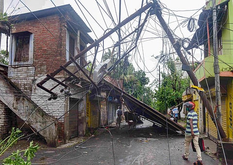 A man walks past a damaged electric post in the aftermath of Cyclone Amphan at Sonarpur in South 24 Parganas district Thursday May 21 2020. (Photo | PTI)