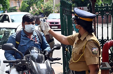 A Health team personnel checking the temperature of a person using infrared thermometer. (Photo | Vincent Pulickal/EPS)