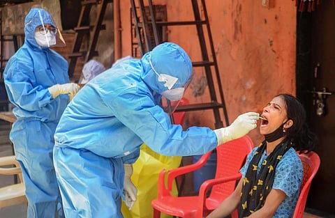 A healthcare worker collecting swab sample from a woman. (Photo | PTI)