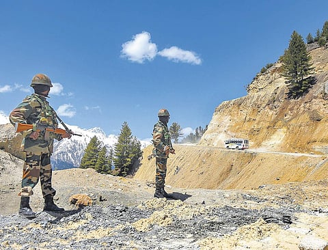 Soldiers stand guard as vehicles pass through Zojila Pass on their way to frontier region of Ladakh (File Photo | PTI)