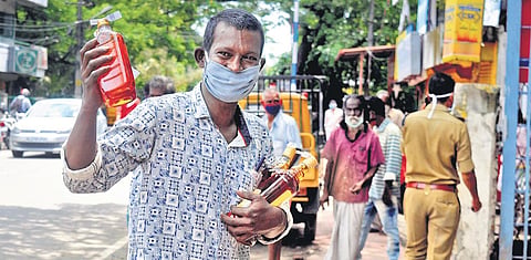 A man with the liquor bottles he bought from a Bevco outlet at Gandhinagar in Kochi on Thursday | A Sanesh