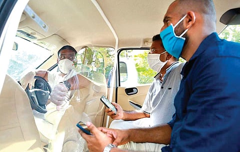 Officials of Ernakulam district administration demonstrate use of fibre clear glass partition inside a taxi to prevent driver from contracting Covid-19 | EXPRESS