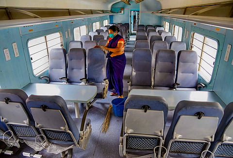 A woman worker cleans seats inside a train coach at Rajendranagar Coaching Complex during ongoing COVID-19 lockdown in Patna Sunday May 31 2020. (Photo | PTI)