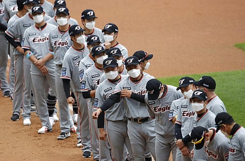 Hanwha Eagles players wearing face masks line up during the start of their regular season baseball game against SK Wyverns in Incheon, South Korea, Tuesday, May 5, 2020. (Photo | AP)