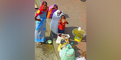 A migrant worker’s family waits to board a bus in Bengaluru | Pandarinath B