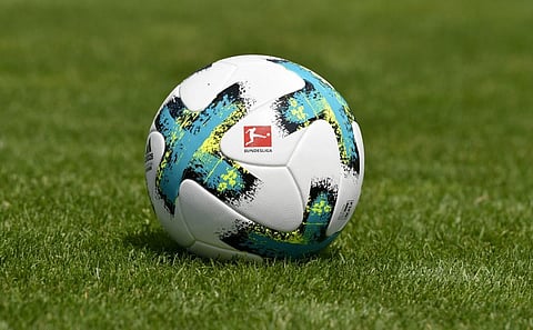 A ball with the logo of the German first division football league Bundesliga is seen on the pitch. (Photo | AFP)