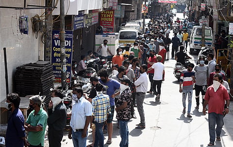 People stand in a queue outside a wine shop after authorities permitted sale of liquor with certain restrictions during the nationwide lockdown in wake of the coronavirus pandemic at Chander Nagar in East Delhi on Tuesday May 5 2020. (Photo | Parveen Negi