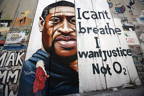 A woman looks at a mural showing the face of George Floyd, an unarmed black man who was killed by Minneapolis police. (Photo |AFP)