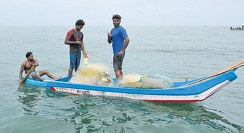 Dharani Selvakumar rows the boat towards the beach as Anand Dandhapani (black T-shirt) and Ajith arrange the net after fishing in Covelong | Shiba Prasad Sahu