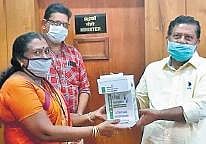 Mini L, principal of BTC, handing over the automatic sanitiser dispenser to U Rajeev, private secretary of Labour Minister T P Ramakrishnan