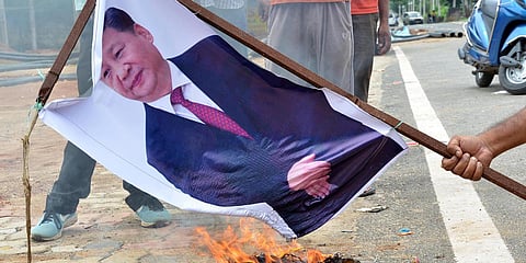 People burn posters of Chinese President Xi Jinping during a protest over the killing of 20 army personnel in Ladakh following a clash with Chinese troops, in Ranchi. (File photo| ANI)