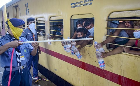 Cadets of Scouts and Guides refill water bottles of migrants sitting in Shramik Special train to reach their native places during ongoing COVID-19 lockdown. ( File Photo | PTI)